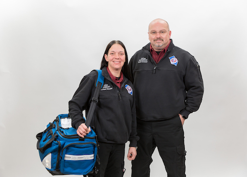 Picture of a female and male EMS employees smiling.
