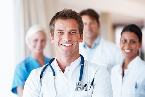 Picture of three Medical Professionals smiling. There is two females and two males.