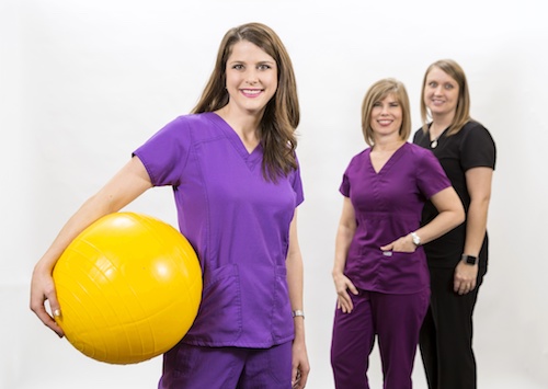 Picture of three female Physical Therapist smiling. One of the Therapist is holding a Therapy Exercise Ball.