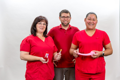 Picture of three Laboratory employees smiling. There is one male and two females.