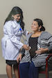 Picture of a female Physician holding a stethoscope on a females patients stomach.