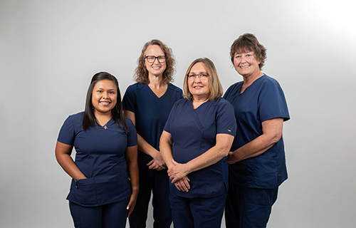 Jackson County Medical Clinic Staff. There is four smiling females. They are wearing scrubs.